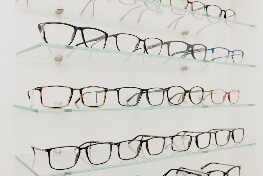 collection of eyeglasses on shelves in store